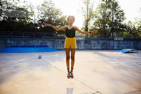 Junge Frau beim Springen in der Luft in einem Skatepark