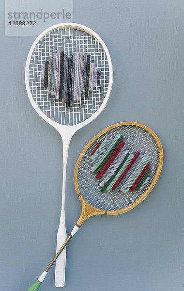 Zwei alte upcycled Badmintonschläger auf grauem Grund