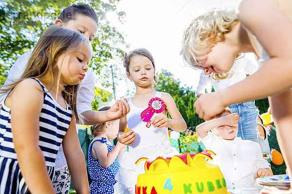 Kinder feiern Geburtstagsfeier im Garten mit Freunden und Familie