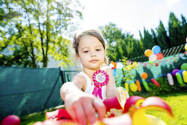 Kleines Mädchen bei der Geburtstagsfeier im Garten