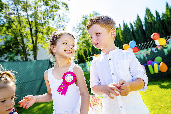 Fröhliche kleine Kinder beim Geburtstagsfest im Garten