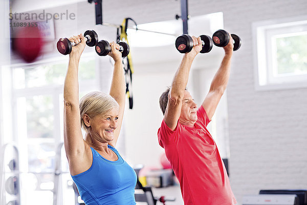Reife Frau und älterer Mann beim Training im Fitnessstudio