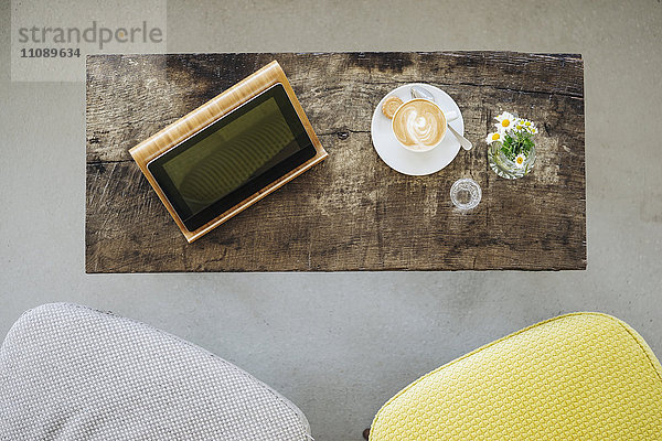 Digitales Tablett und Tasse Kaffee auf dem Tisch in einem Cafe