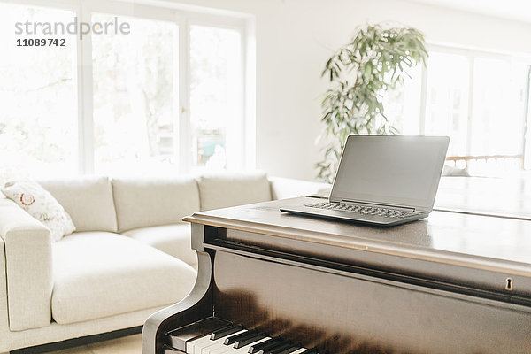 Laptop stehend auf Klavier im Wohnzimmer