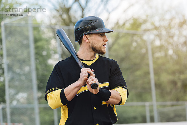 Baseballspieler hält Schläger