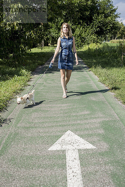 Frau geht mit ihrem Chihuahua spazieren.