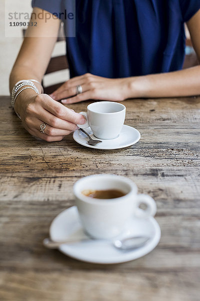 Frau trinkt Espresso in einem Straßencafé  Teilansicht