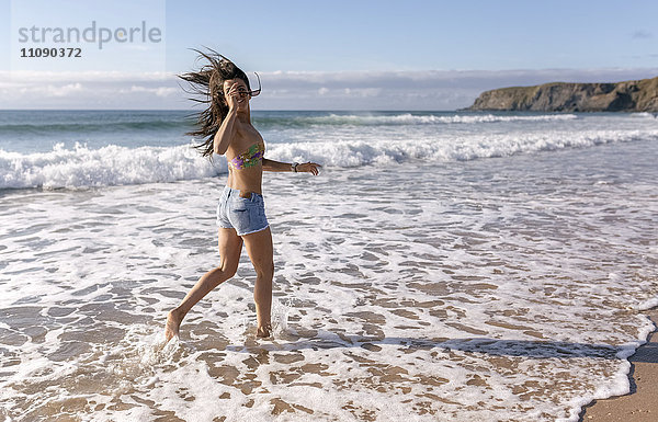 Spain  Asturias  beautiful young woman running on the beach