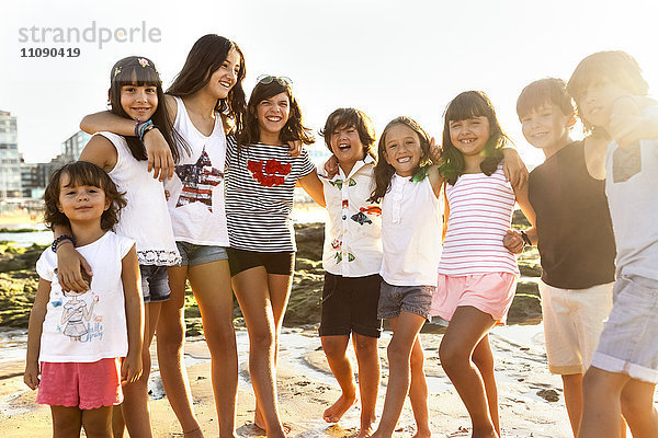 Kindergruppe am Strand bei Sonnenuntergang