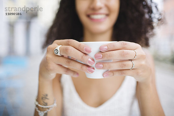 Hände einer jungen Frau mit einer Tasse Kaffee  Nahaufnahme