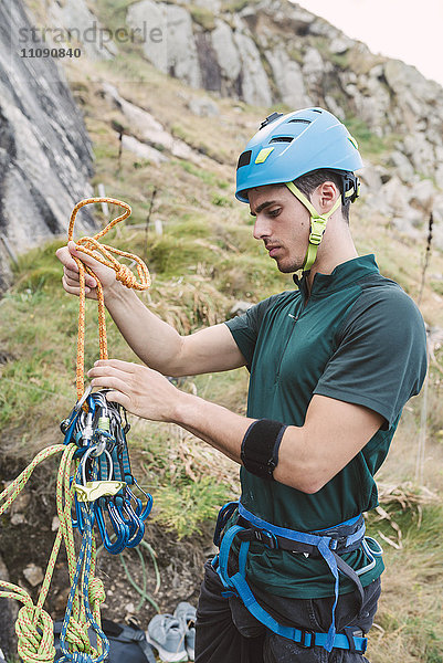 Junger Mann bei der Vorbereitung der Kletterausrüstung