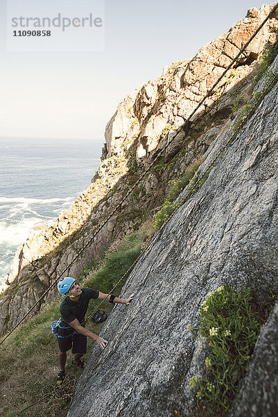 Kletterer schaut eine Felswand hinauf