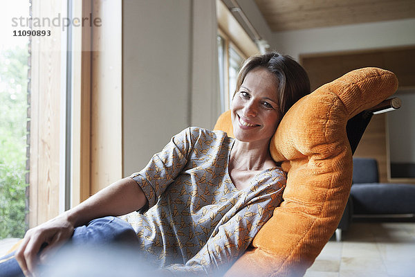 Lächelnde Frau entspannt im Sessel