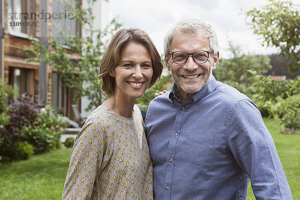 Porträt eines lächelnden reifen Paares im Garten