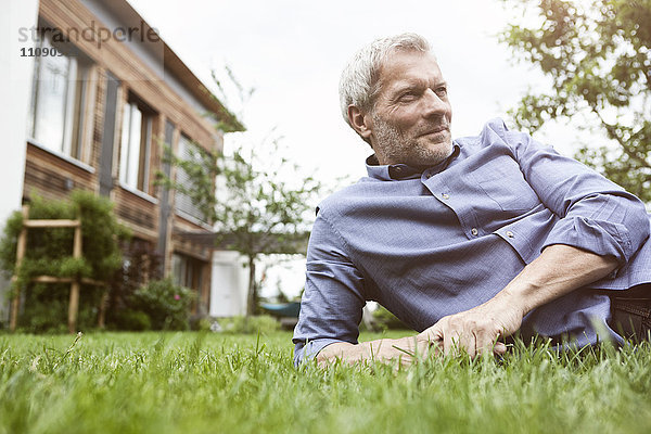 Erwachsener Mann im Garten liegend