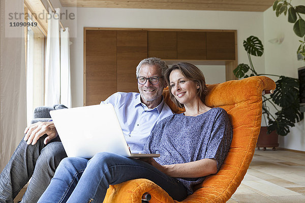 Reife Paare  die sich zu Hause einen Laptop teilen