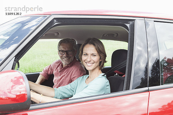 Porträt eines glücklichen reifen Paares im Auto