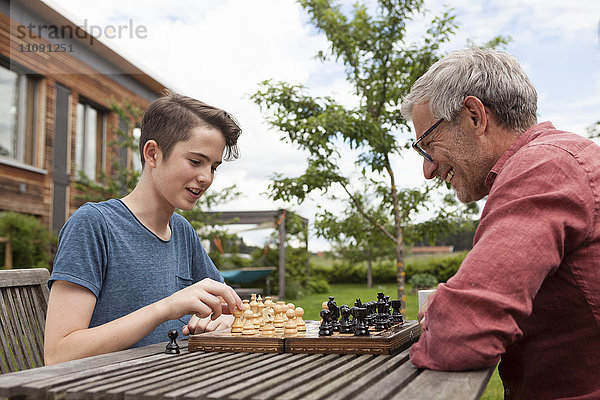 Vater und Sohn beim Schachspielen im Garten