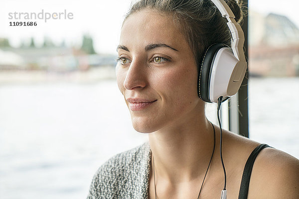 Porträt einer entspannten Frau beim Musikhören mit Kopfhörern