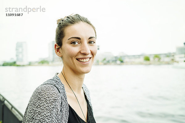 Porträt einer lächelnden Frau am Flussufer