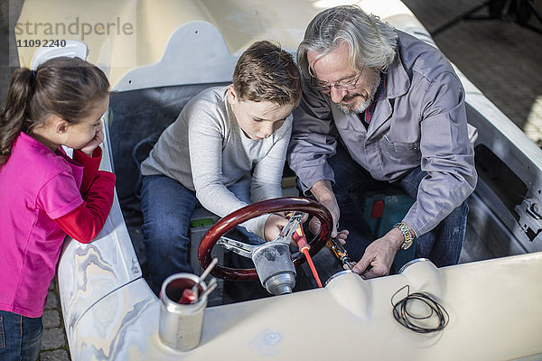 Senior Mann mit Junge und Mädchen in einem Cabriolet zum restaurieren