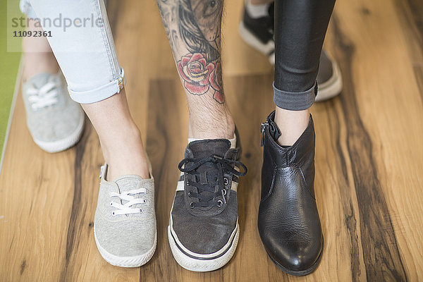 Drei Personen zeigen ihre unterschiedlichen Schuhe