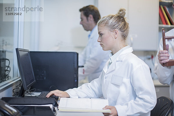 Junge Frau bei der Arbeit am Computer im Labor