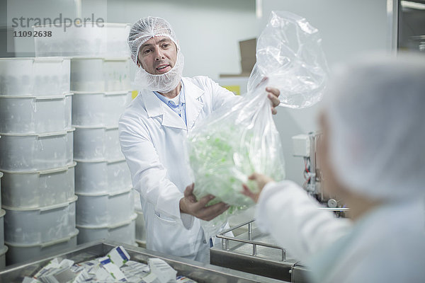 Laborant im Pharmawerk bei der Übergabe der Plastiktüte