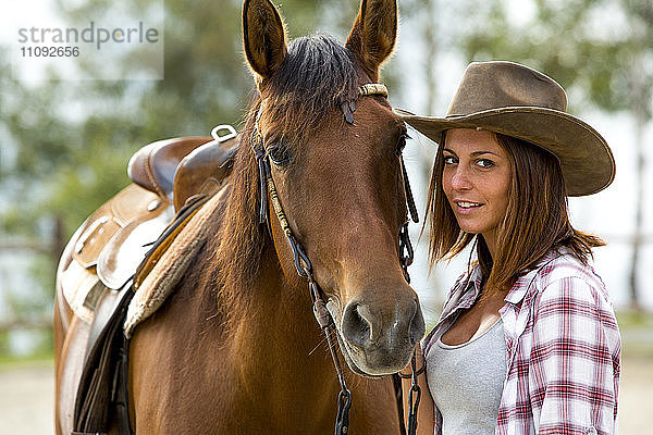 Young woman with horse at riding stable