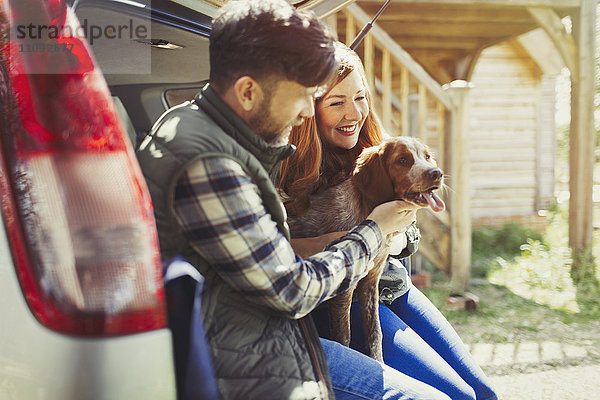 Paar streichelnder Hund hinten im Auto