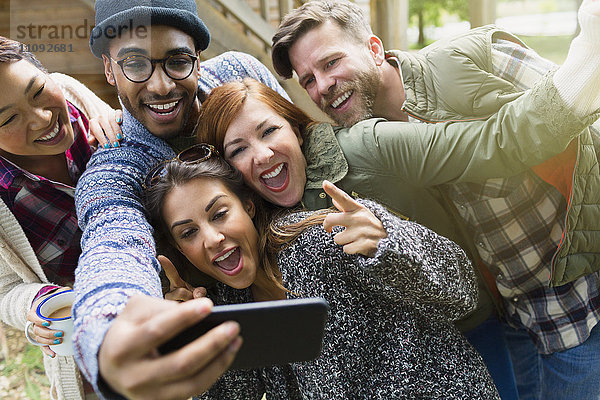 Verspielte Freunde mit Kamerahandygesten  die Selfie nehmen.