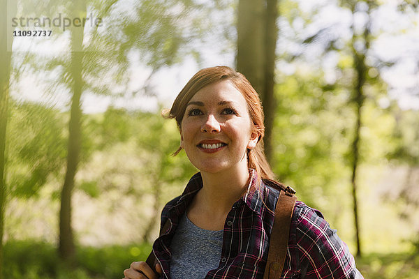 Portrait lächelnde Frau mit roten Haaren beim Wandern im Wald