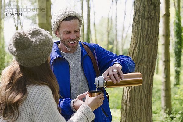 Paar Wander- und Trinkkaffee aus isoliertem Getränkebehälter im Wald