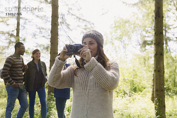 Frau beim Kamerawandern im Wald