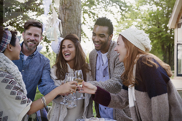 Freunde toasten Champagnergläser auf der Terrasse