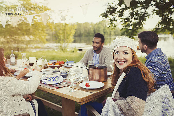 Portrait lächelnde Frau beim Mittagessen am Seeterrassen-Tisch