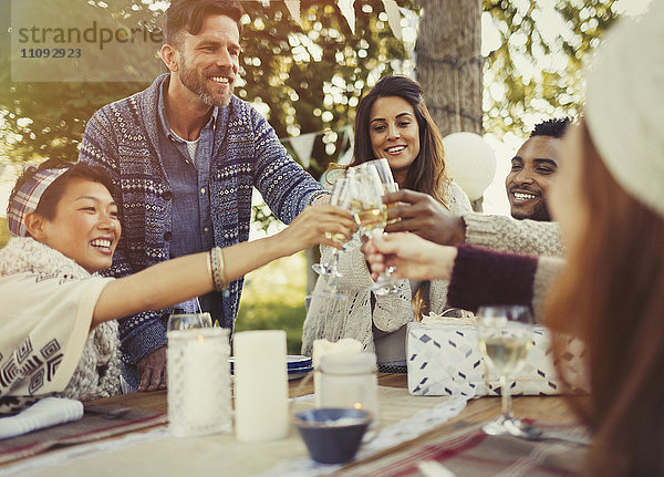 Freunde toasten Champagnergläser am Geburtstagsparty-Tisch