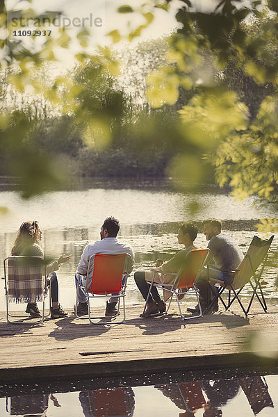 Freunde sprechen am sonnigen Hafen am Seeufer