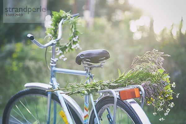 Blumen und Girlanden auf dem Fahrrad im Garten