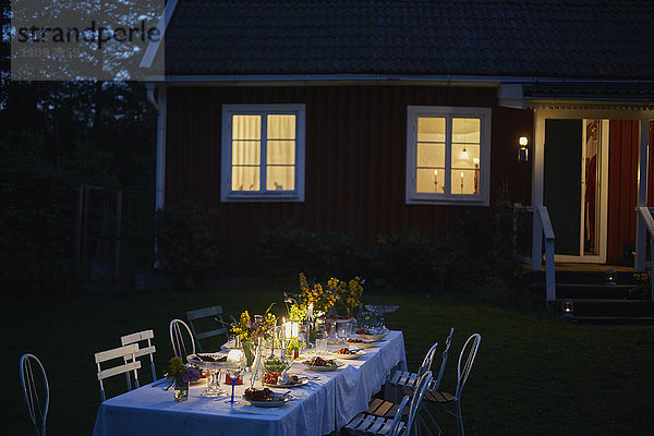 Candlelight Garden Party Dinner im Freien beleuchtetes Haus bei Nacht