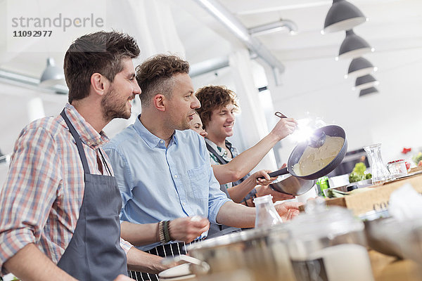 Männliche Studenten genießen den Kochunterricht in der Küche