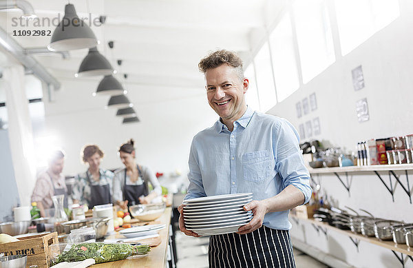 Portrait lächelnder Mann in der Küche des Kochkurses