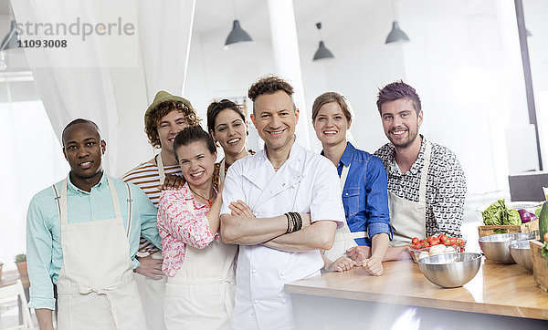 Portrait lächelnder Kochlehrer und Schüler in der Kochklasse Küche