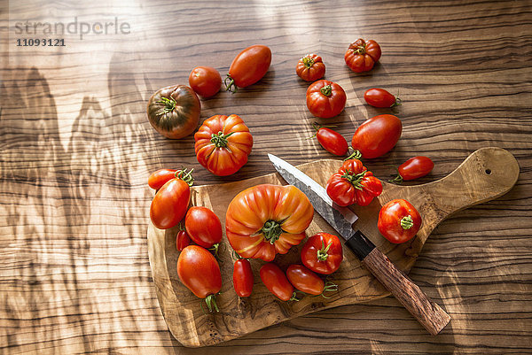 Direkt über der Aufnahme einer Tomatensorte mit Messer auf Schneidebrett  München  Bayern  Deutschland