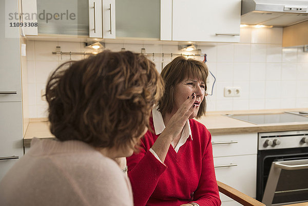 Zwei ältere Frauen unterhalten sich in der Küche