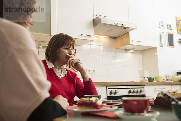 Zwei ältere Frauen führen ein ernstes Gespräch in der Küche