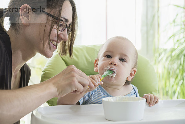 Mutter füttert ihren kleinen Jungen mit einem Löffel mit Babynahrung  München  Bayern  Deutschland