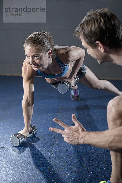 Fitness-Manager beim Training eines Kunden im Fitnessstudio