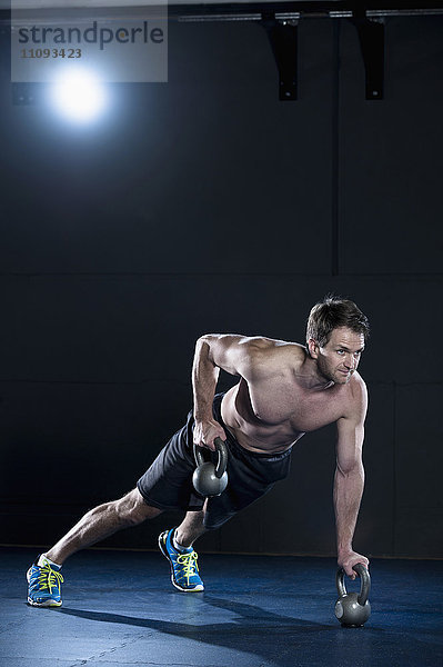 Sportler beim Training im Fitnessstudio mit Kettlebell