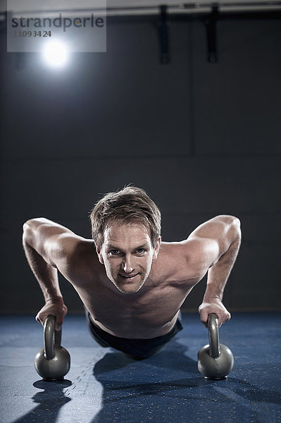 Sportler beim Training im Fitnessstudio mit Kettlebell